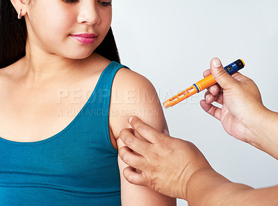 Buy stock photo Studio shot of a cute young girl getting an insulin shot from an unrecognizable woman against a gray background