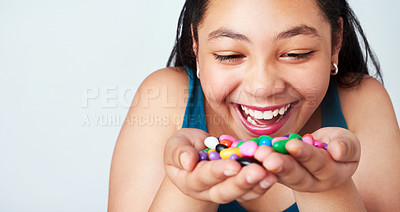 Buy stock photo Girl, eating or candy or smile at reward, wow or omg of motivation, success or growth on mockup. Excited, female child or hand of jelly beans in thinking, treasure or prize at achievement in studio