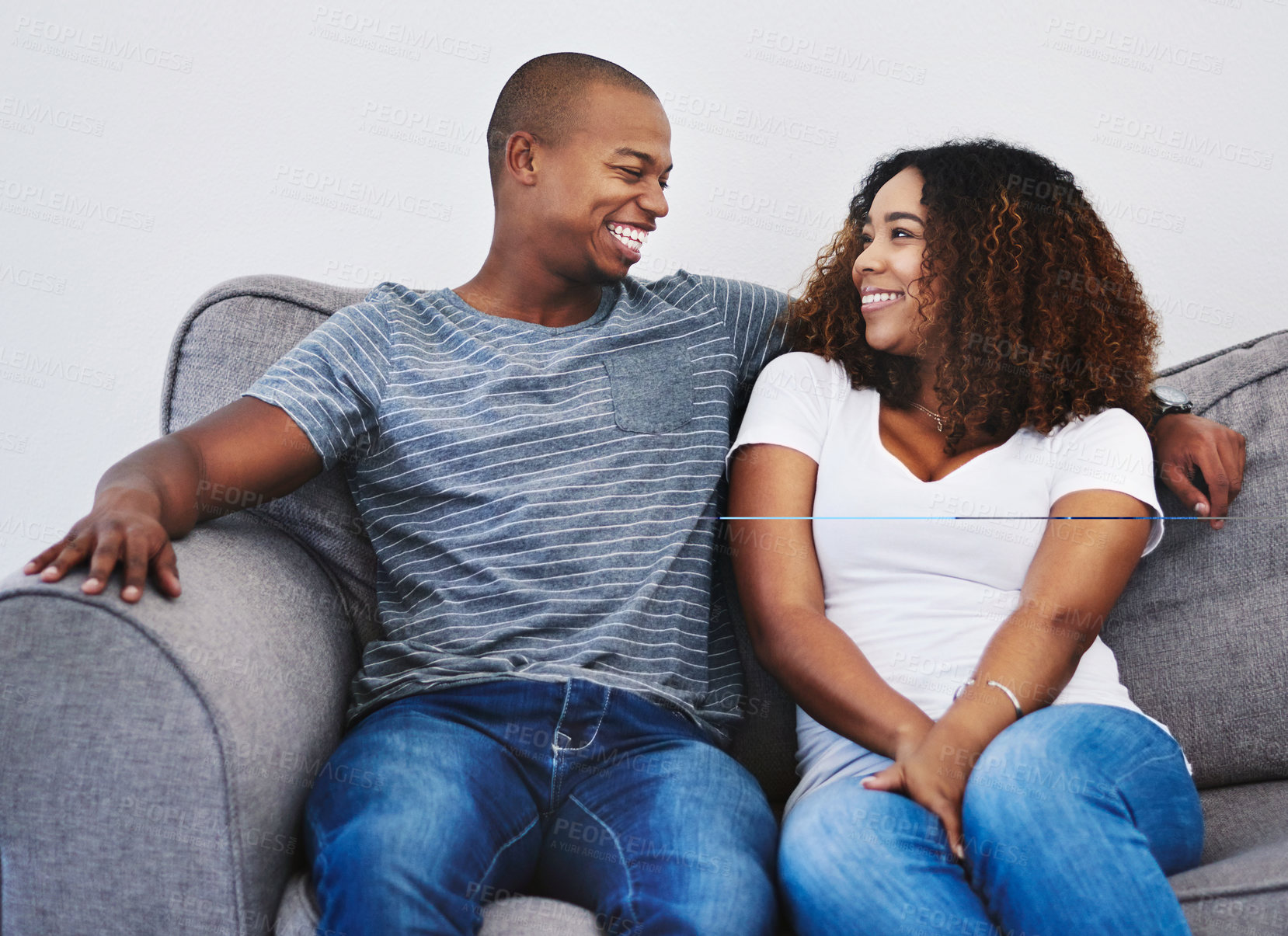 Buy stock photo Shot of a young couple relaxing together at home