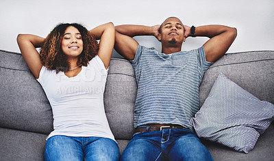 Buy stock photo Shot of a young couple resting on a couch at home