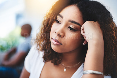 Buy stock photo Shot of a young woman looking despondent after having a fight with her partner at home