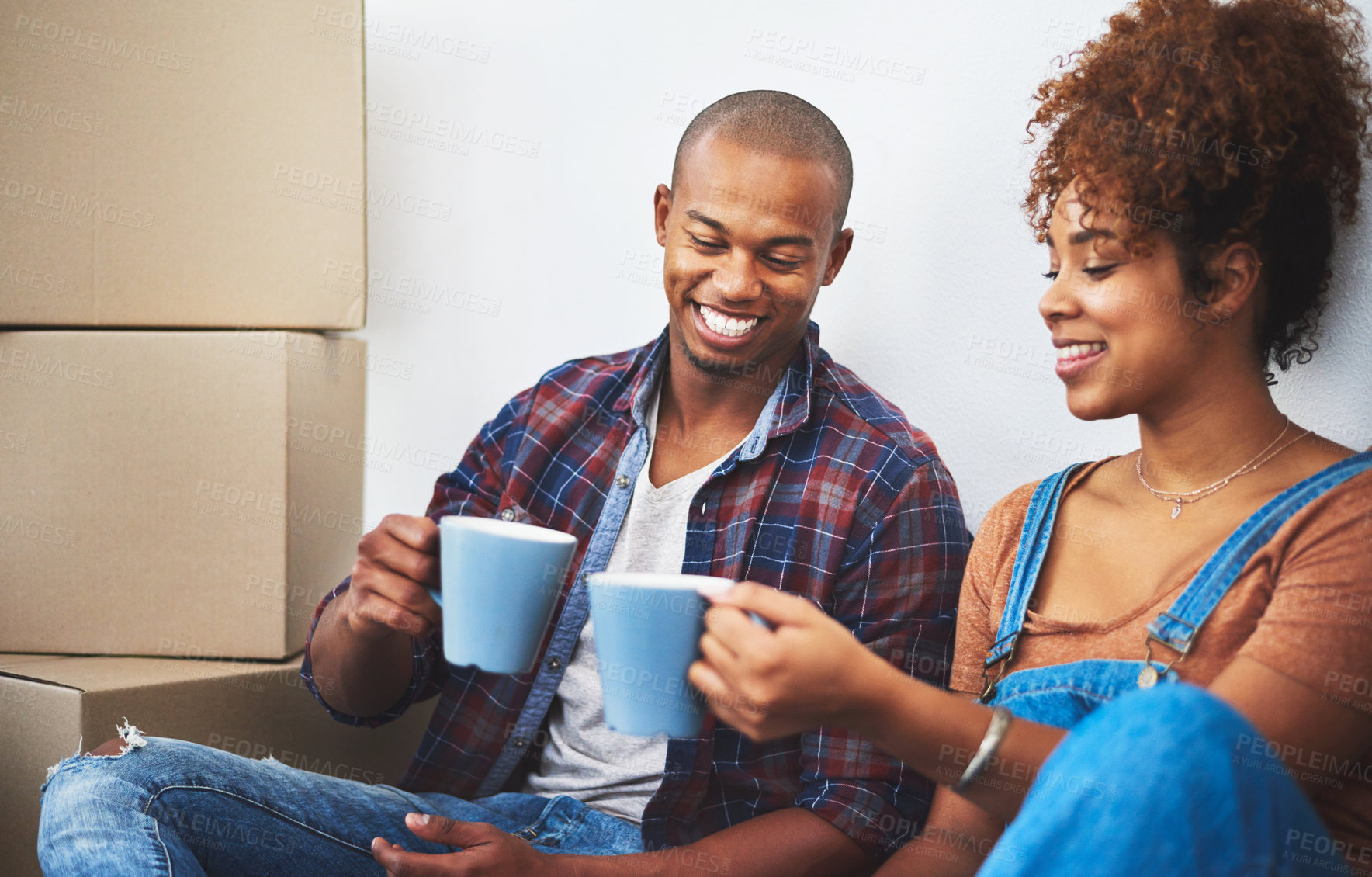 Buy stock photo Couple, smile and coffee in new house with boxes for moving, investment and rental property. People, toast for success and happy in living room on floor with package, apartment and real estate