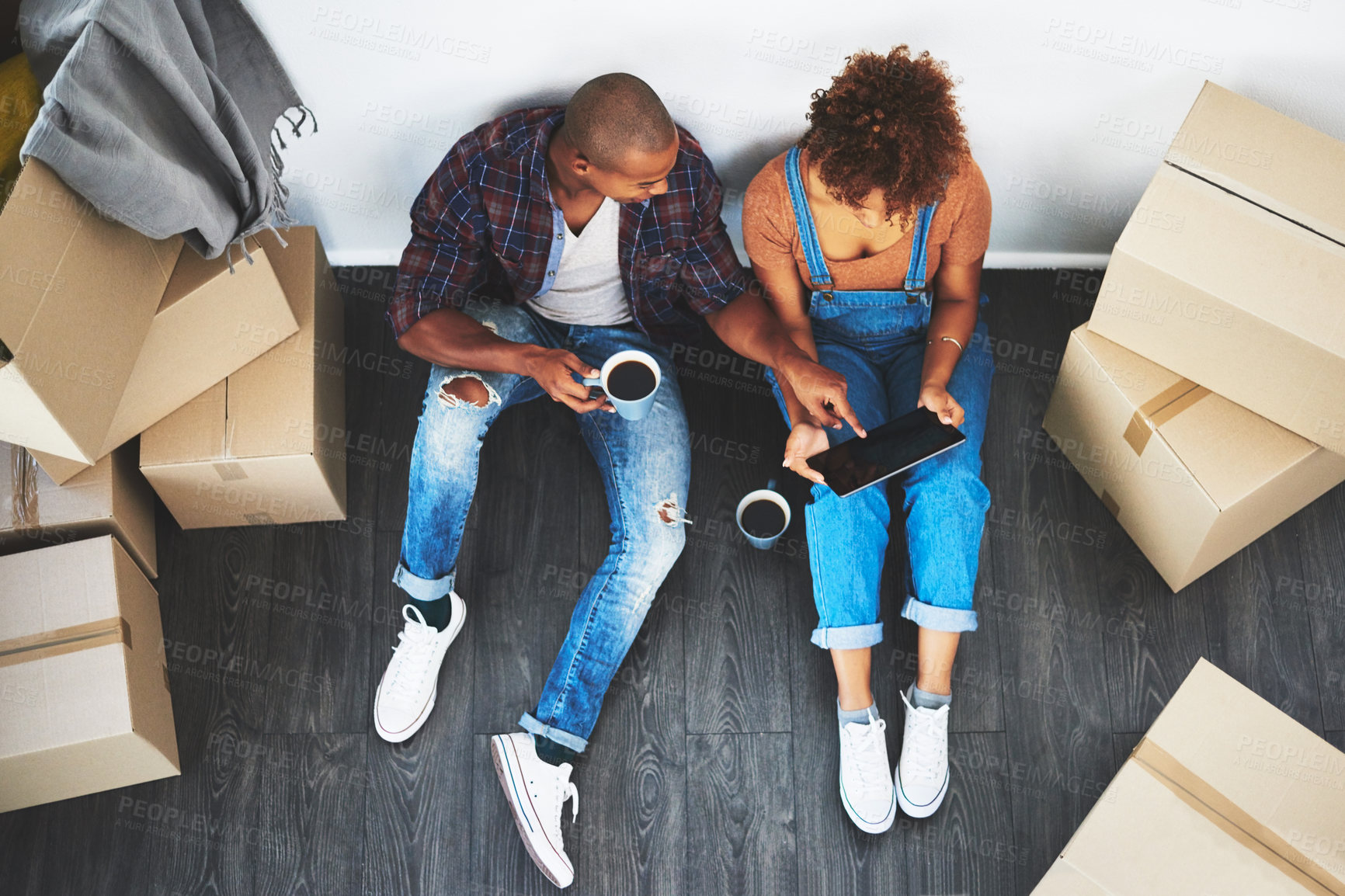 Buy stock photo Digital tablet, coffee and couple with boxes planning their new apartment together on the floor. Technology, caffeine and top view of man and woman doing property research on mobile moving in a home.