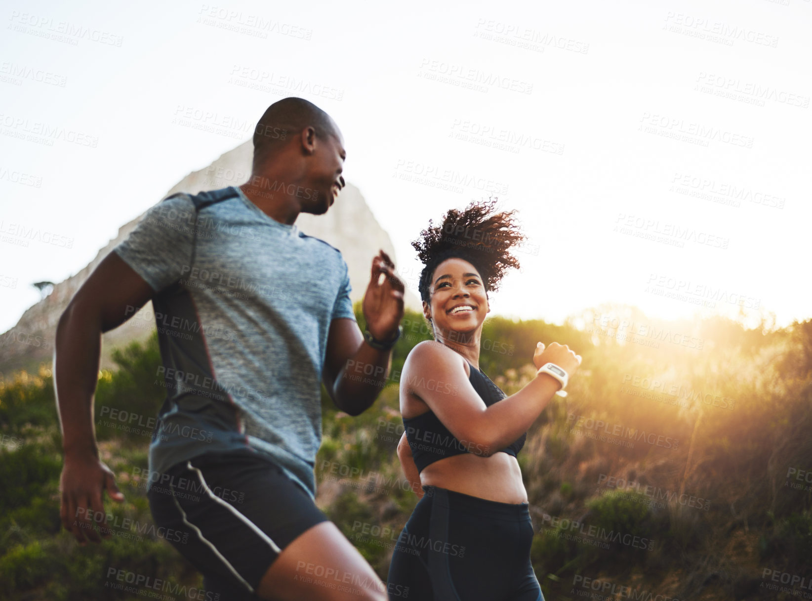 Buy stock photo Fitness, energy and athletes running in nature by a mountain training for race, marathon or competition. Sports, health and African couple doing outdoor cardio workout or exercise together at sunset.