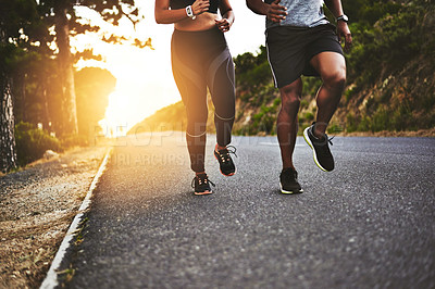 Buy stock photo Low angle shot of an unrecognizable couple out running together
