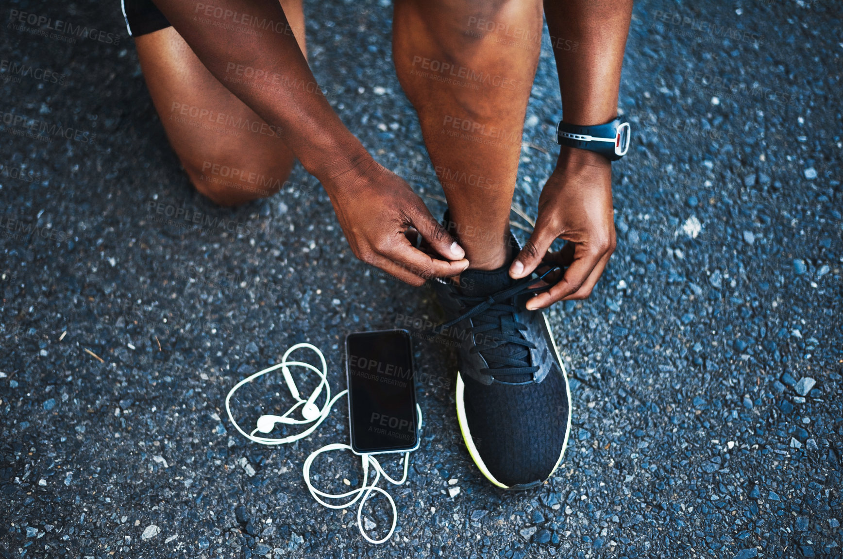 Buy stock photo Cropped shot of an unrecognizable man tying his shoelaces