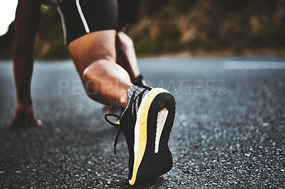 Buy stock photo Low angle shot of a man out exercising on a tarmac road