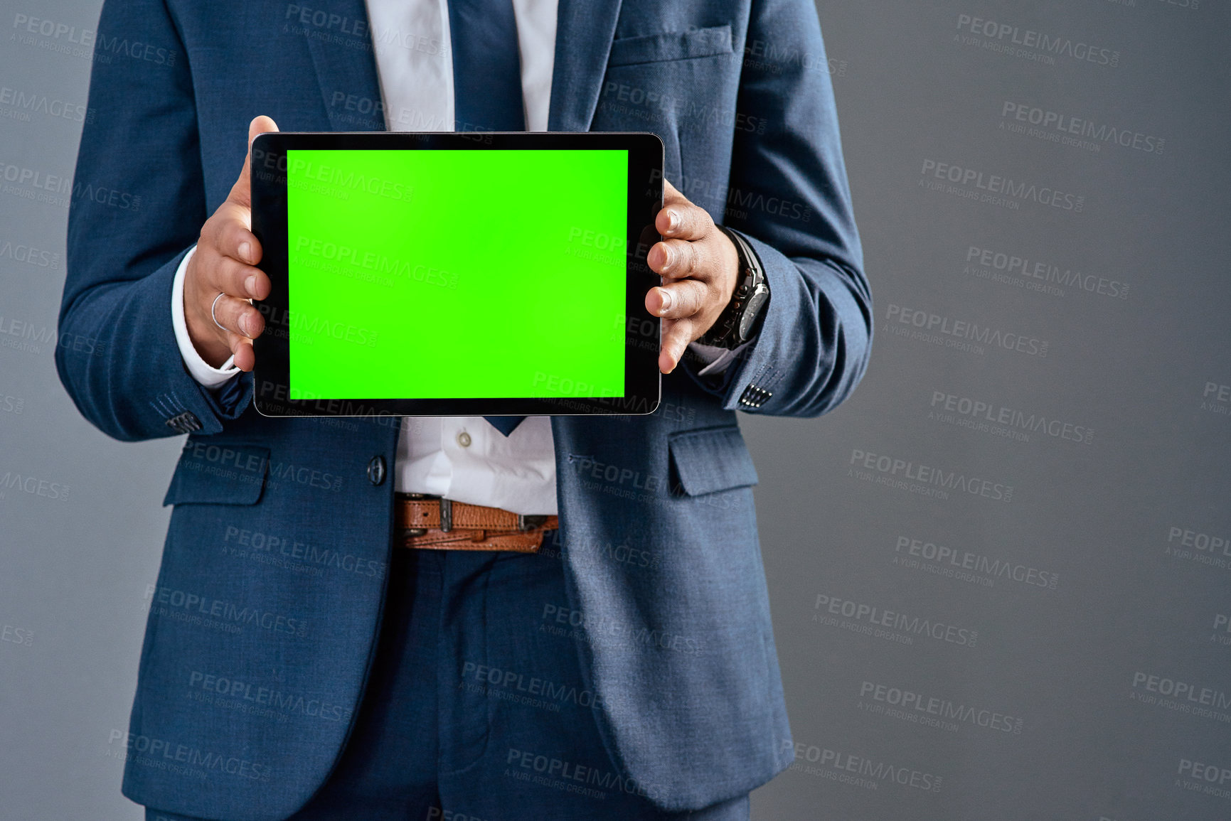 Buy stock photo Studio shot of an unrecognizable corporate businessman holding a tablet against a grey background