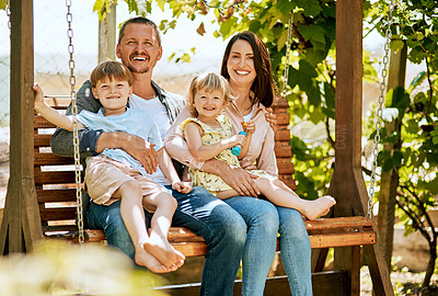 Buy stock photo Portrait of a family of four relaxing together on a garden swing