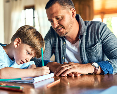 Buy stock photo Shot of a father helping his son with his homework