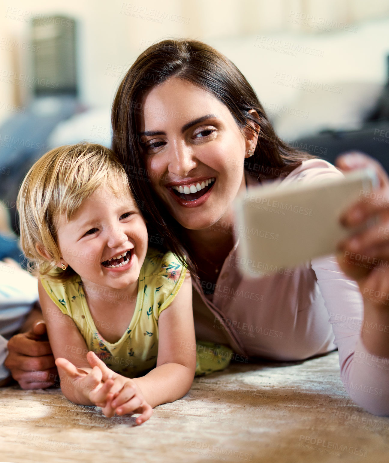 Buy stock photo Shot of a happy mother and her adorable daughter taking selfies together at home