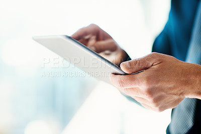 Buy stock photo Cropped shot of an unrecognizable businessman working on a digital tablet