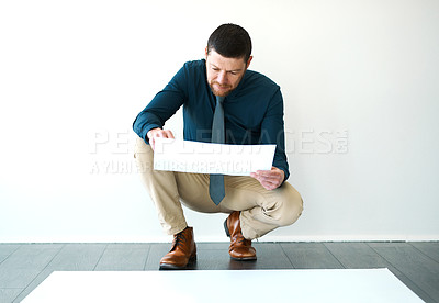 Buy stock photo Full length shot of a handsome mature male architect looking over some paperwork
