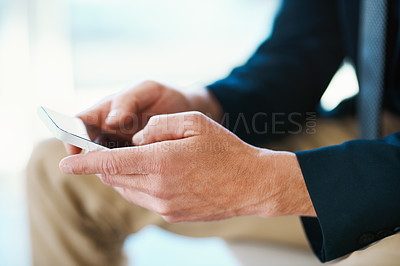 Buy stock photo High angle shot of an unrecognizable businessman sending a text message