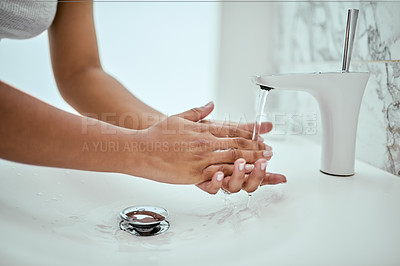 Buy stock photo Shot of an unrecognizable woman's hands being washed at a basin in a bathroom at home during the day