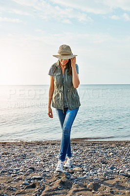 Buy stock photo Shot of an attractive young woman enjoying a walk by the lake