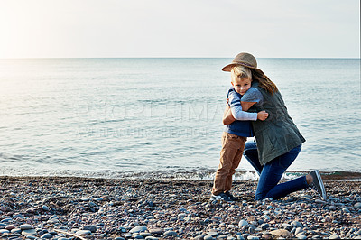 Buy stock photo Shot of a loving mother hugging her son while out by the lake