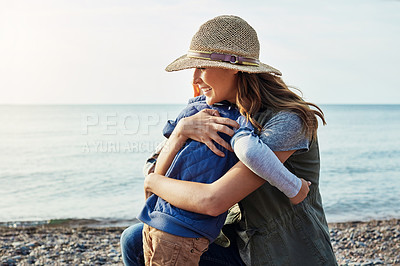 Buy stock photo Shot of a loving mother hugging her son while out by the lake