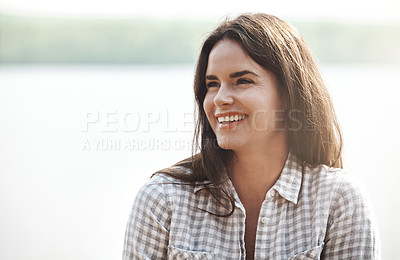 Buy stock photo Shot of an attractive young woman relaxing at the lake