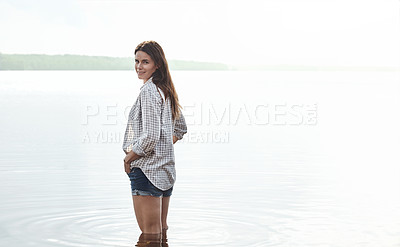 Buy stock photo Portrait of an attractive young woman standing in a lake