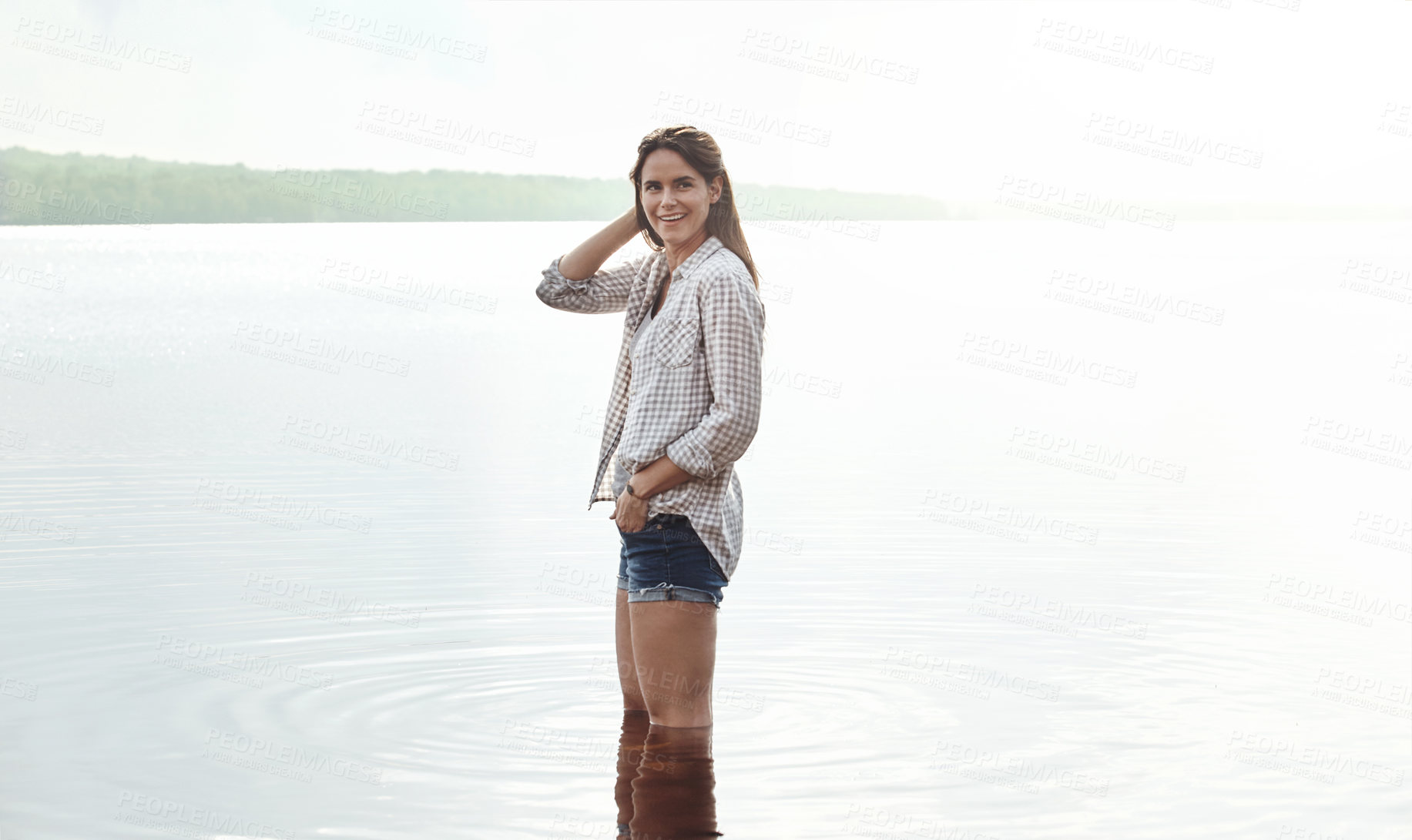 Buy stock photo Portrait of an attractive young woman standing in a lake