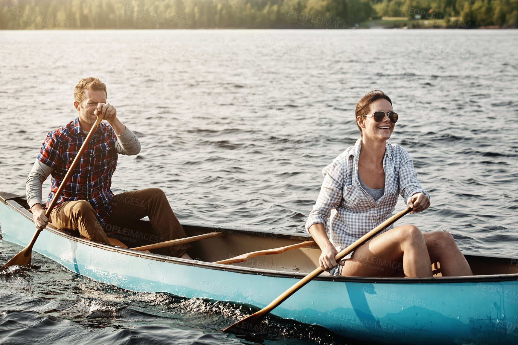 Buy stock photo Shot of a young couple going for a canoe ride on the lake