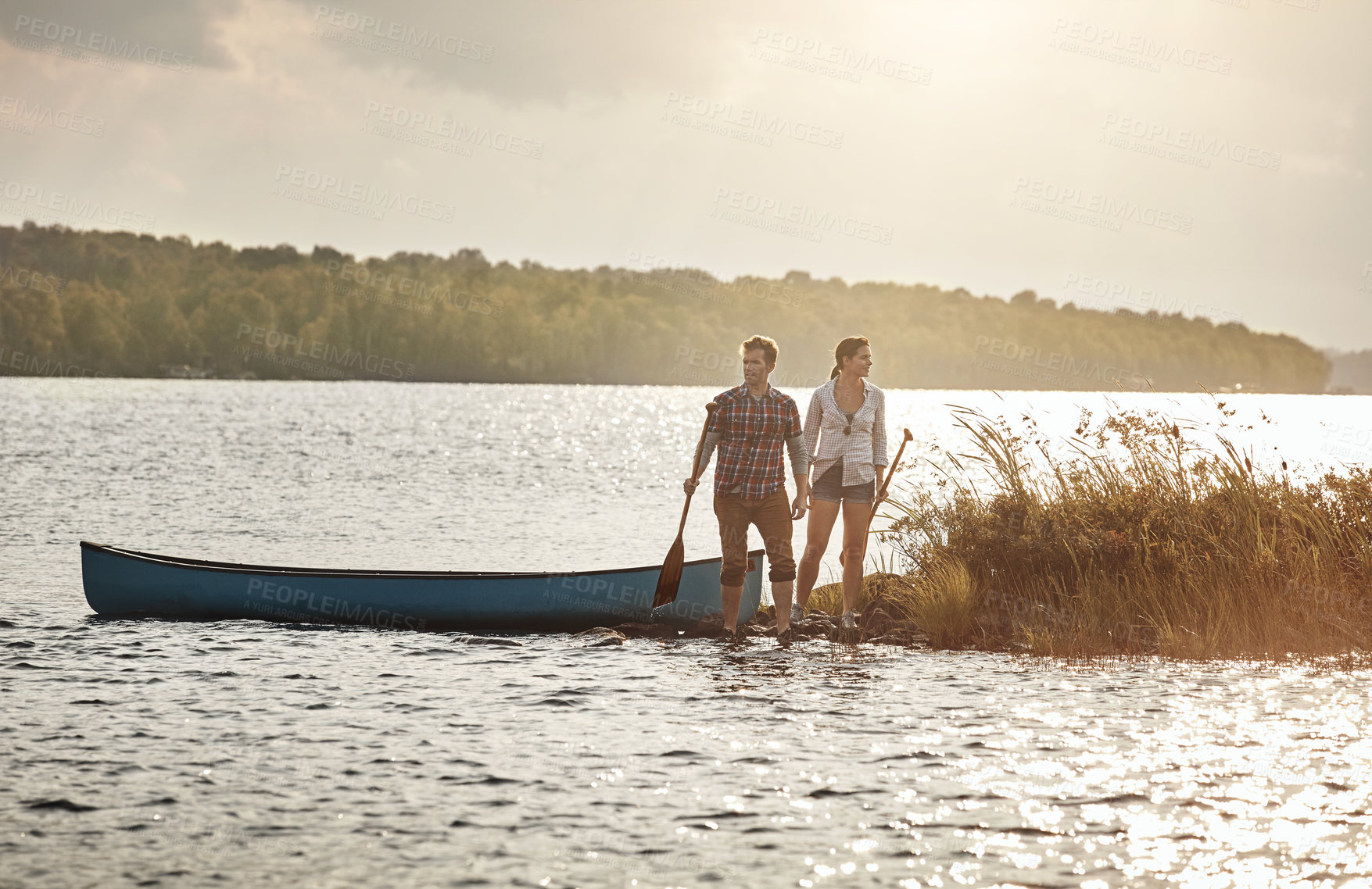 Buy stock photo Shot of a young couple going for a canoe ride on the lake