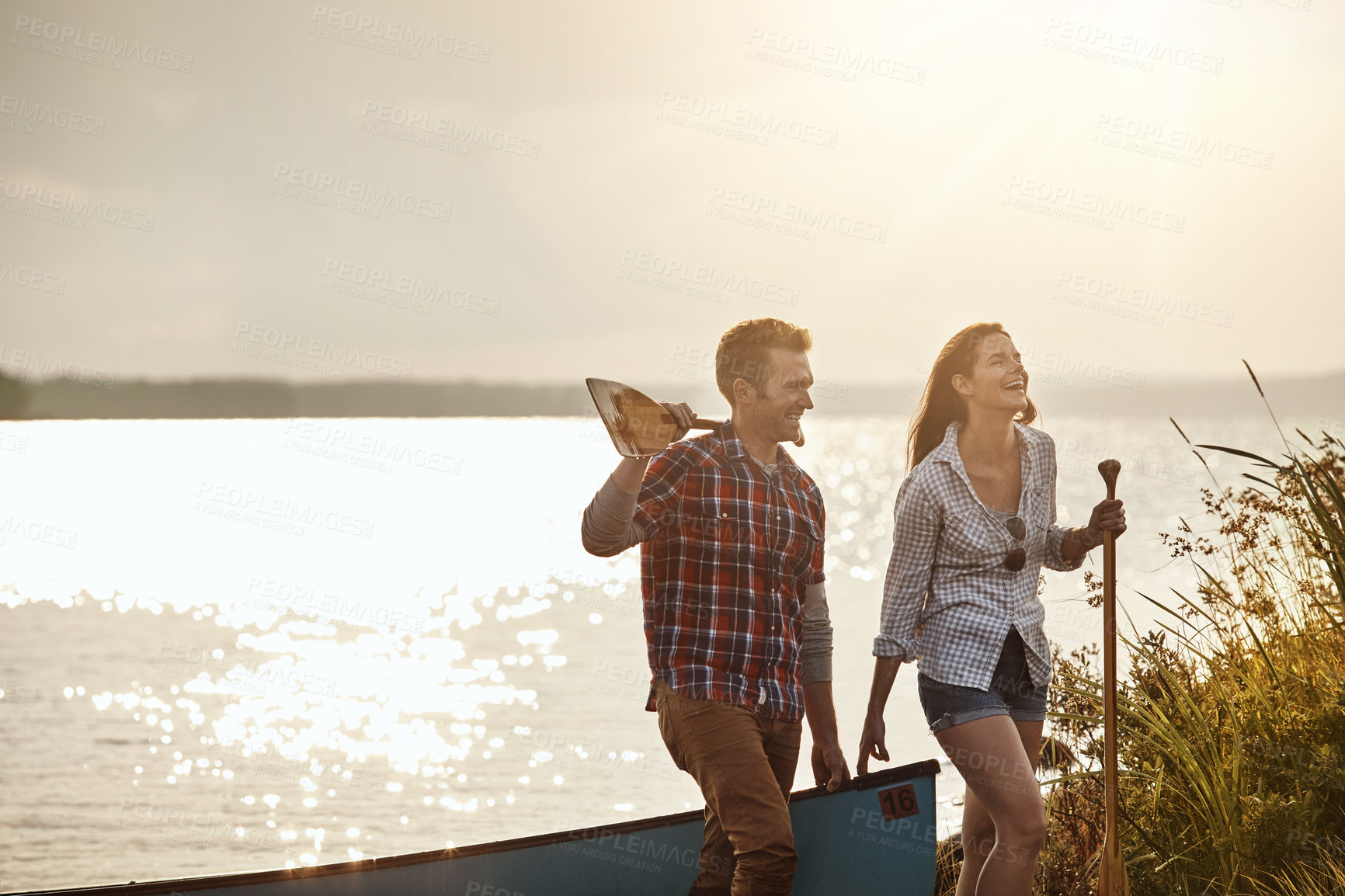 Buy stock photo Shot of a young couple going for a canoe ride on the lake