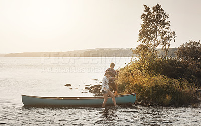 Buy stock photo Shot of a young couple going for a canoe ride on the lake