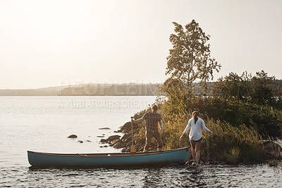 Buy stock photo Shot of a young couple going for a canoe ride on the lake