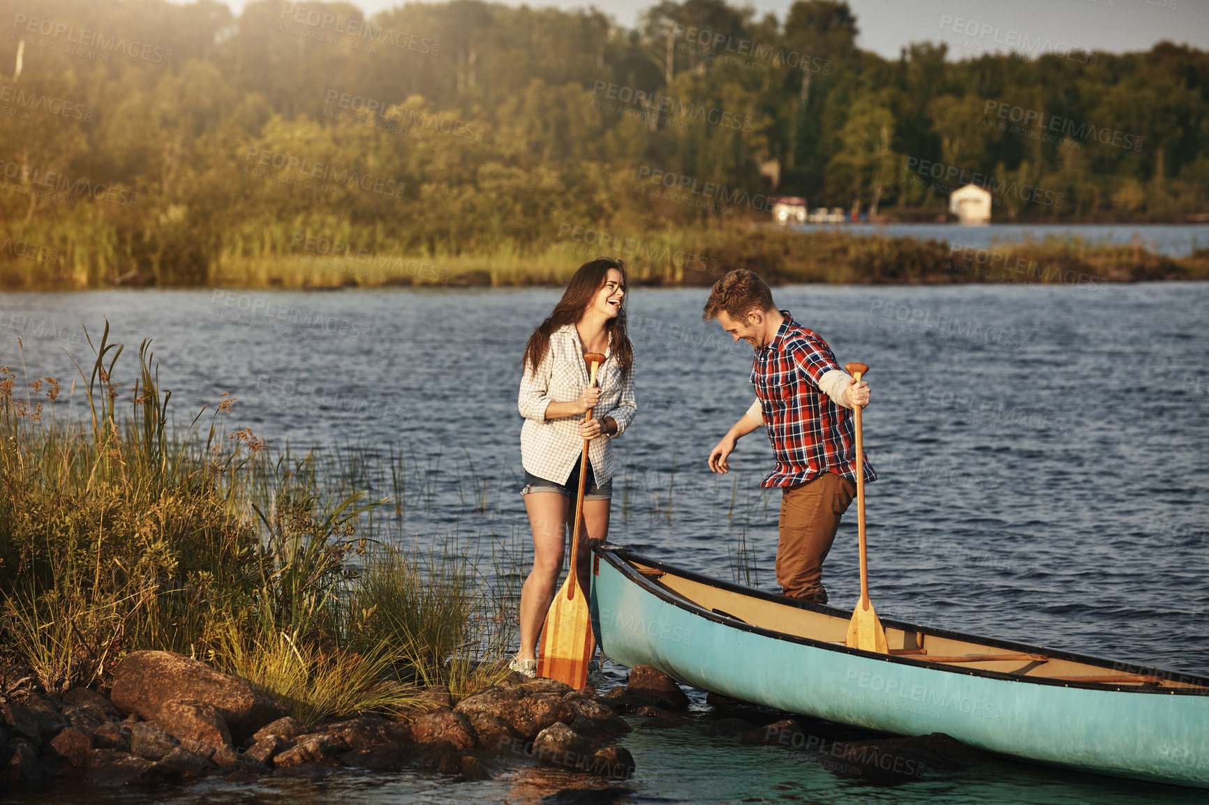 Buy stock photo Shot of a young couple going for a canoe ride on the lake