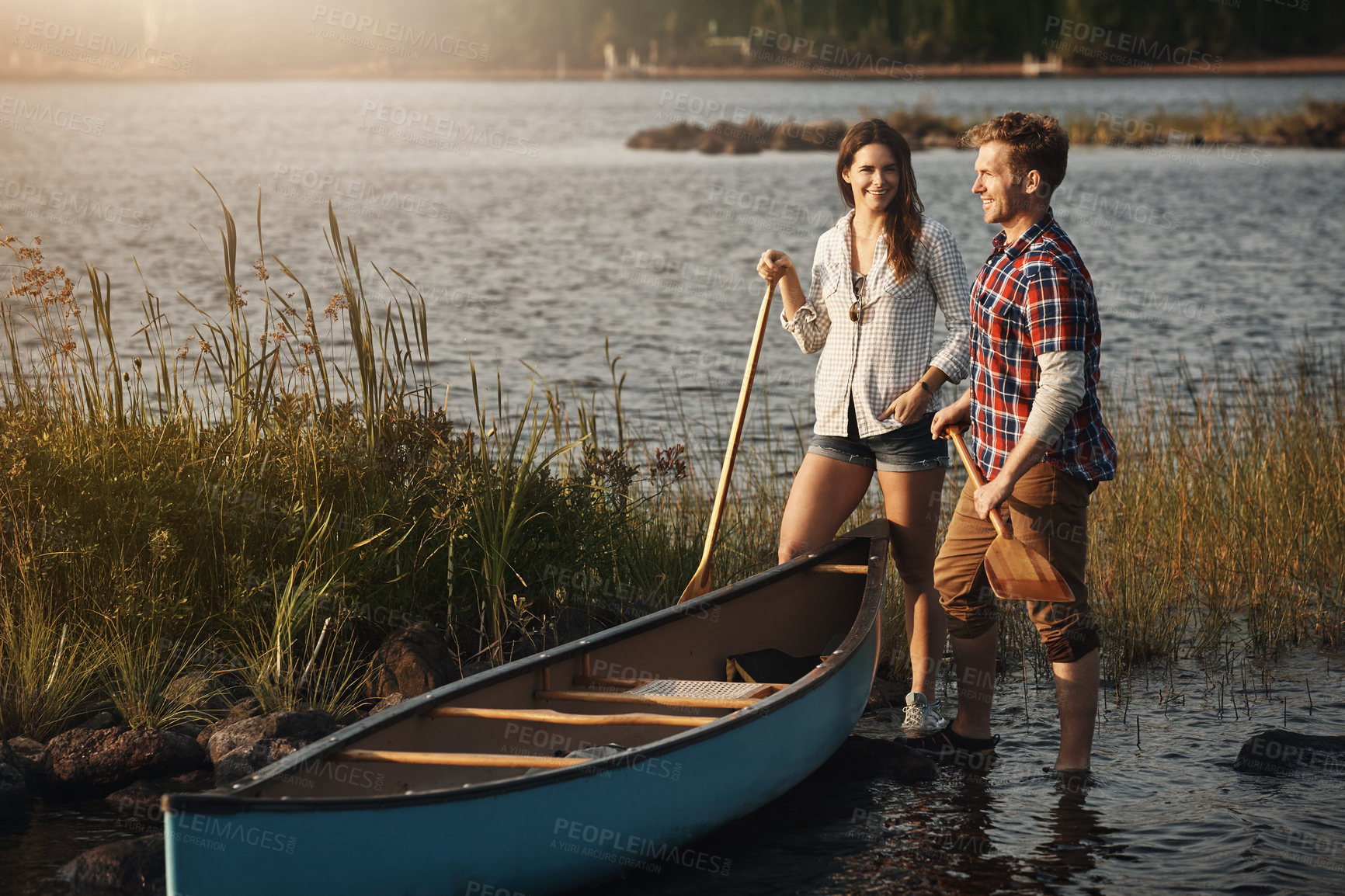 Buy stock photo Shot of a young couple going for a canoe ride on the lake