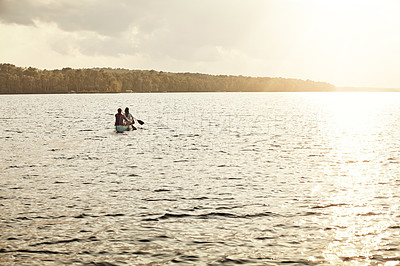 Buy stock photo Shot of an unrecognizable couple rowing a boat out on the lake