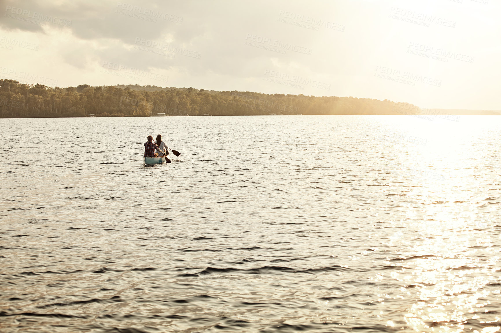 Buy stock photo Shot of an unrecognizable couple rowing a boat out on the lake