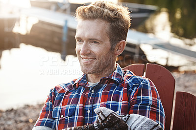 Buy stock photo Shot of a handsome young man relaxing on a deck chair outdoors
