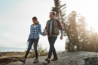 Buy stock photo Shot of a happy couple out hiking hand in hand