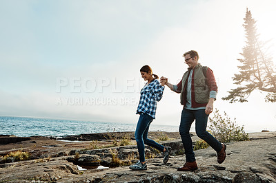 Buy stock photo Shot of a happy couple out hiking hand in hand