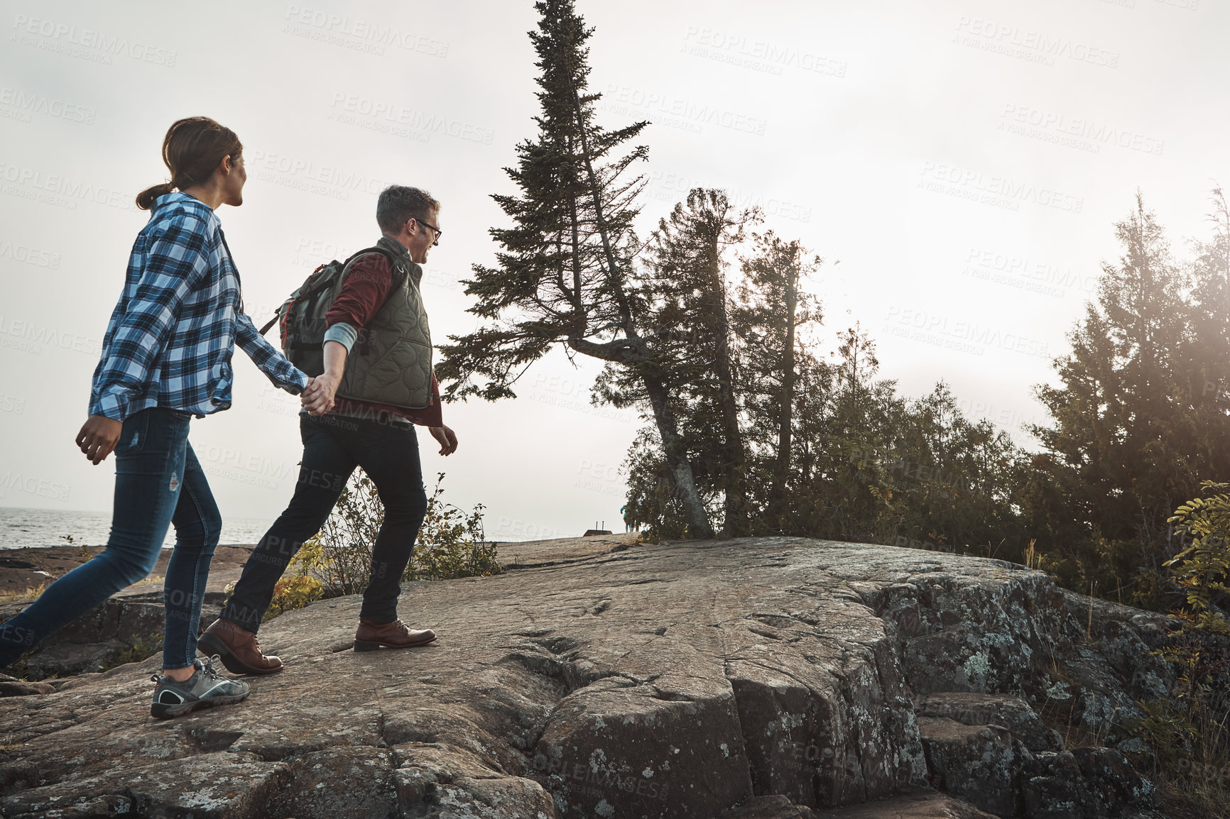 Buy stock photo Shot of a happy couple out hiking hand in hand