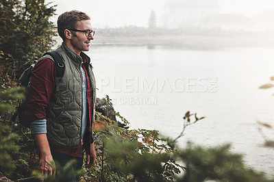 Buy stock photo Shot of an adventurous male backpacker out for a hike in nature