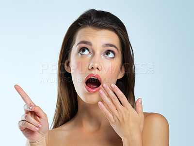 Buy stock photo Wow, shocked and pointing woman isolated on blue background beauty sale, discount or makeup promotion. Surprise face of cosmetics model or gossip person in studio showing mockup or product placement