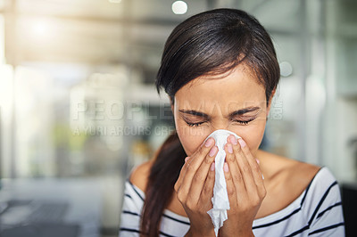 Buy stock photo Cropped shot of a young businesswoman blowing her nose with a tissue in the office