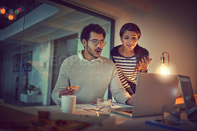 Buy stock photo Shot of two young designers working late on a laptop in an office
