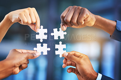 Buy stock photo Cropped shot of a group of businesspeople completing a puzzle together in a modern office