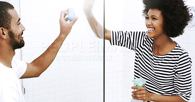 Buy stock photo Shot of a cheerful young couple washing a glass shower door together with a sponge in the bathroom at home