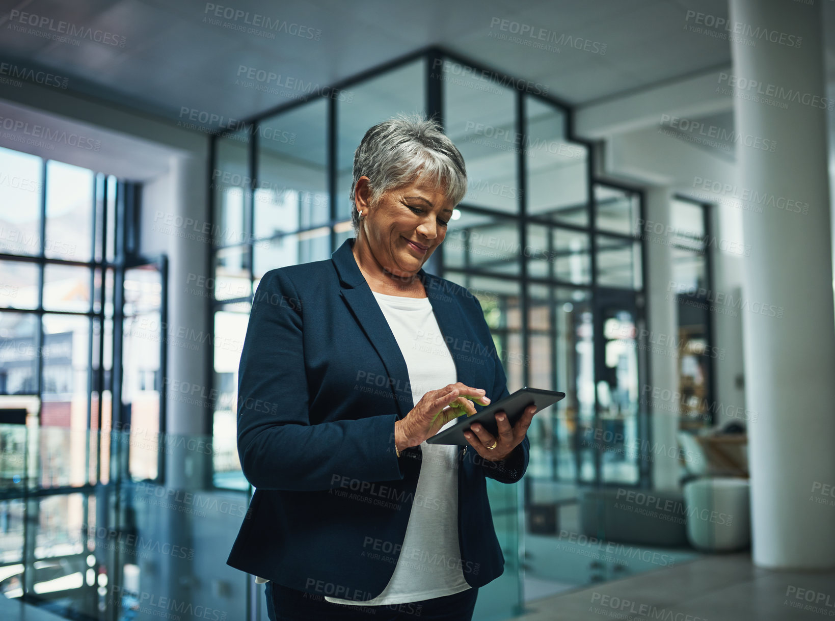 Buy stock photo Shot of a mature businesswoman using a digital tablet in an office