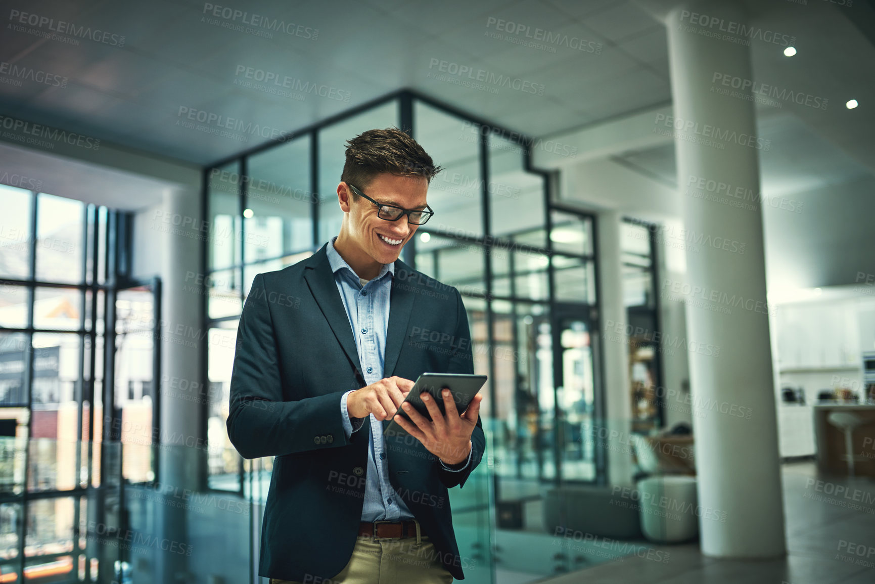 Buy stock photo Shot of a young businessman using a digital tablet in an office