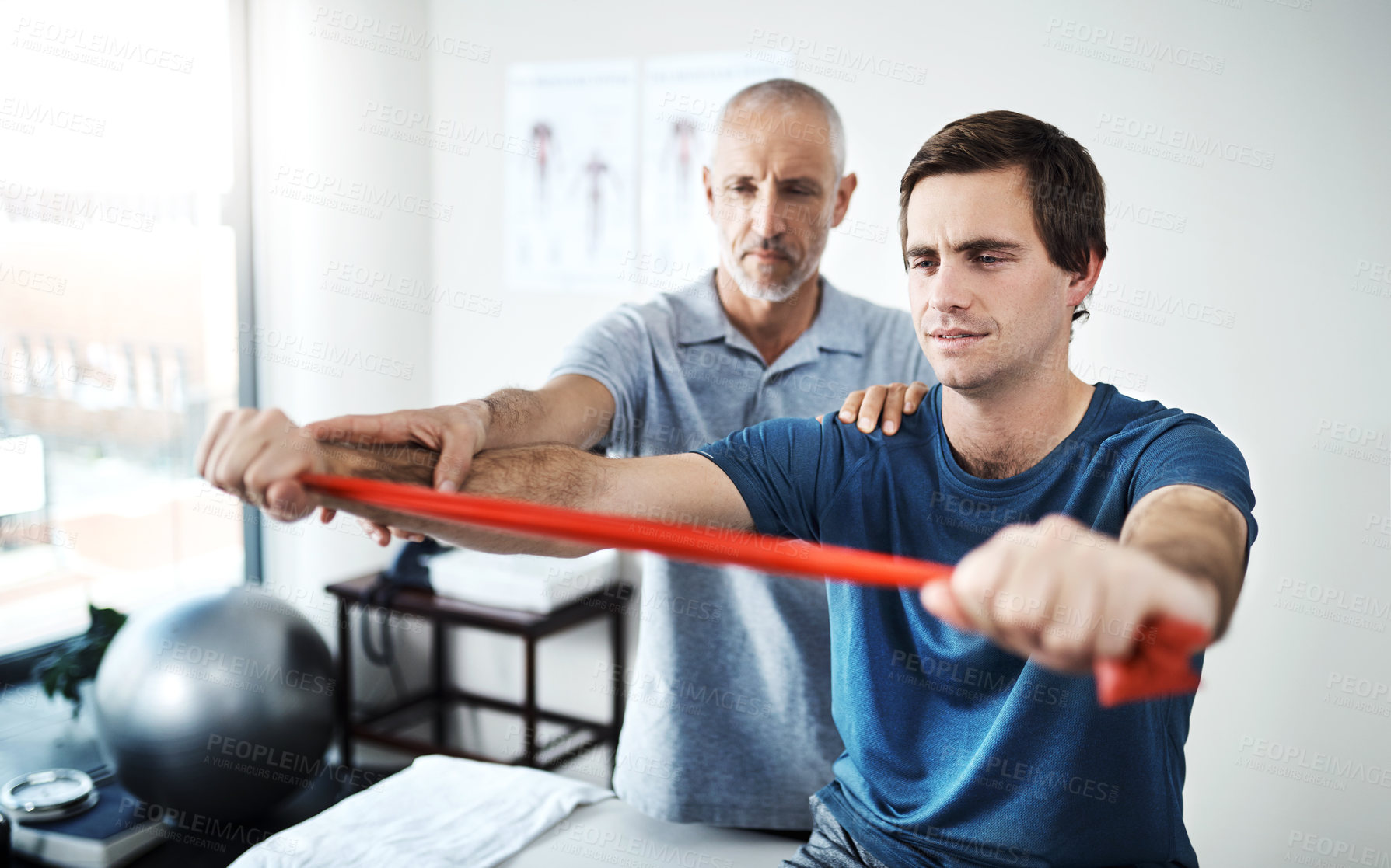 Buy stock photo Resistance band, strength training and man with physiotherapist in office for appointment or checkup. Exercise, fitness and medicine professional with physiotherapy patient in rehabilitation clinic