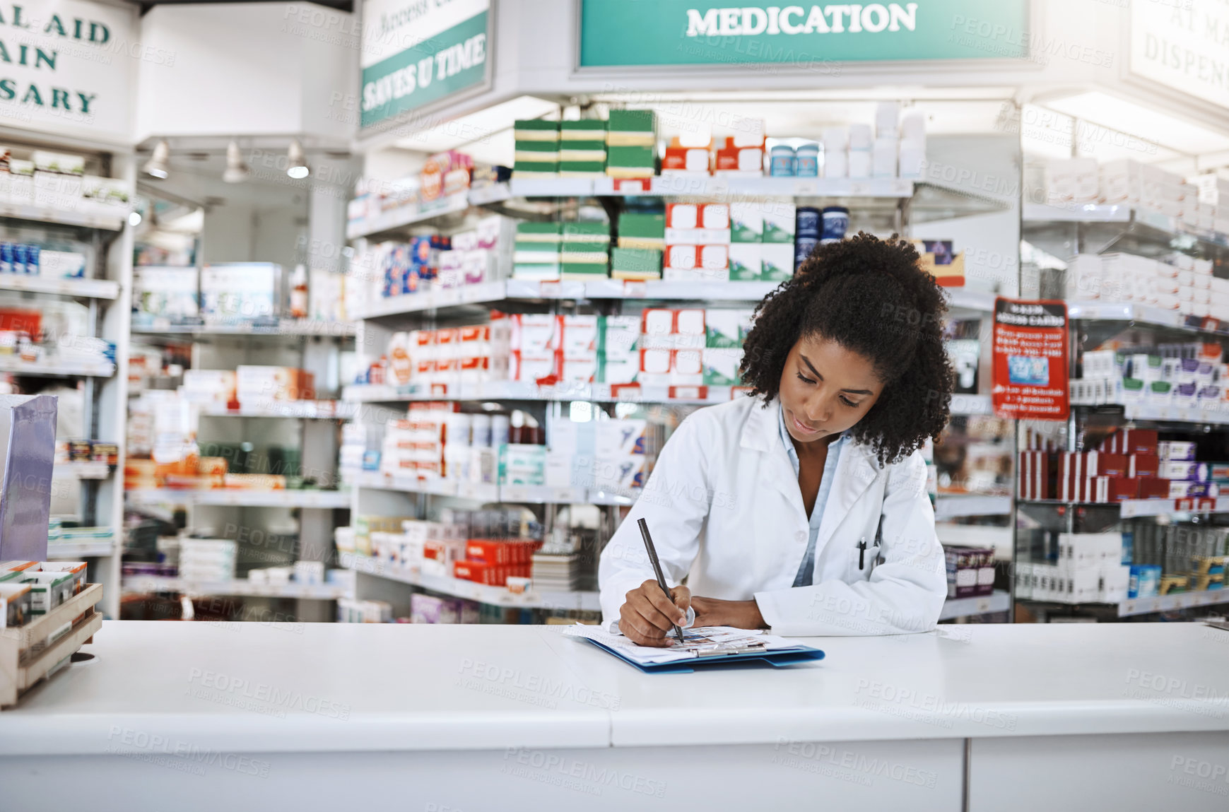 Buy stock photo Cropped shot of an attractive young female pharmacist working in a pharmacy