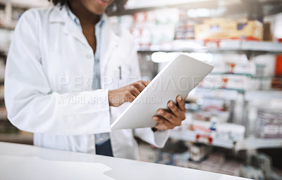 Buy stock photo Cropped shot of an unrecognizable young female pharmacist working in a pharmacy