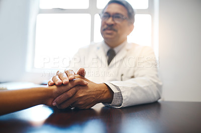 Buy stock photo Shot of a mature doctor holding a patient's hand in comfort